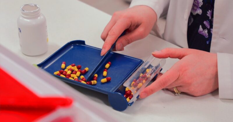pharmacist sorting pills in trey