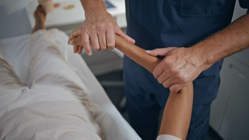 Physiotherapist stretching a patient’s arm during a rehabilitation session