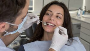 Dentist examining a patient’s front teeth with dental instruments.